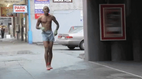 the man is running down the sidewalk in his underwear