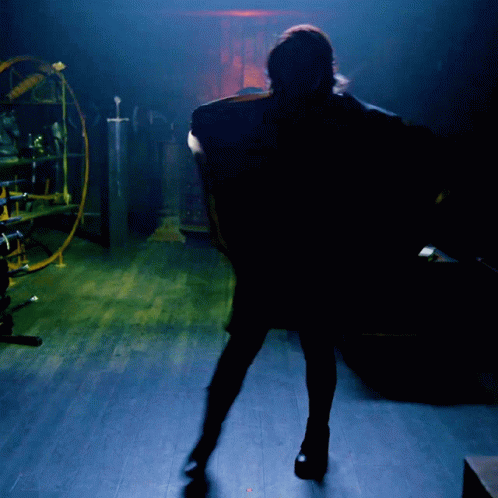 a woman is walking in the dark on the floor