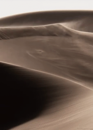 a mountain landscape with black sand dunes
