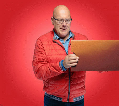 a man with glasses and a blue jacket holds a laptop