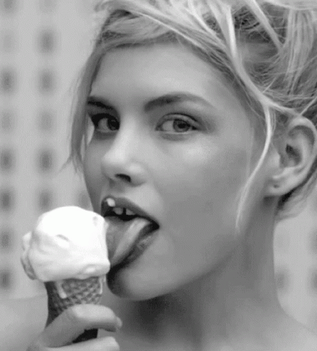black and white pograph of a woman eating an ice cream cone