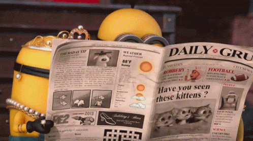 a blue and white toy robot reading a newspaper