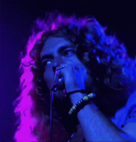 a male performing with a microphone in his hand