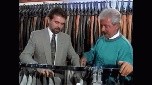 two men looking at clothes on display in the closet