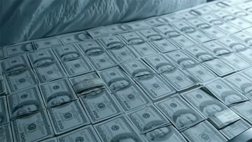 a bed that is full of money with some white sheets