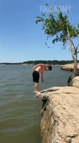 a young man balances on the edge of a lake