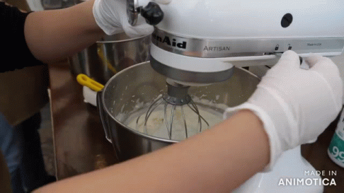 the woman is making the cake with a mixer