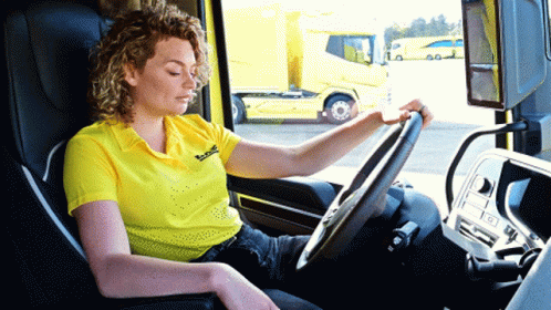 a woman is driving a bus and she's looking at the drivers dashboard