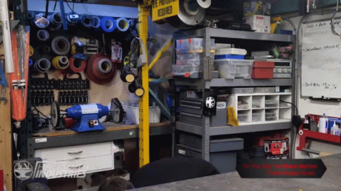 many tools are inside a workshop with blue shelves