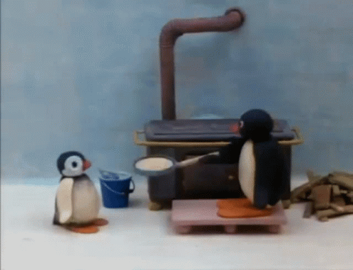 two small penguins and a plastic chair in a room