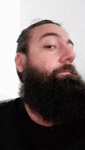 man wearing black shirt with beard and beard piercing