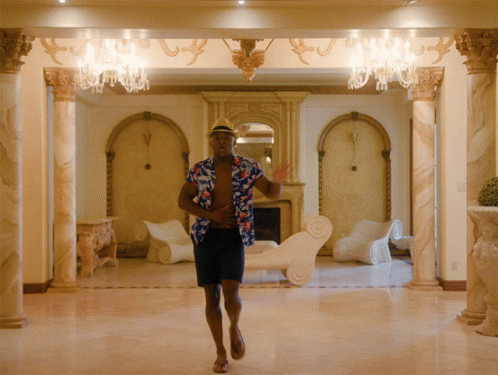 a man walking through a room filled with columns