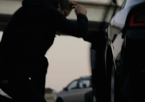 a man is fixing the side door handle on a black car