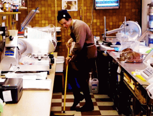 a man standing in front of a counter covered in lots of clutter