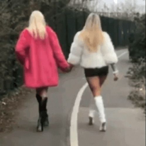 two women in black boots walking down the street