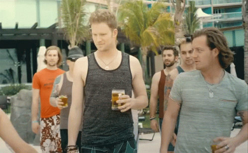 four guys are standing close together having drinks