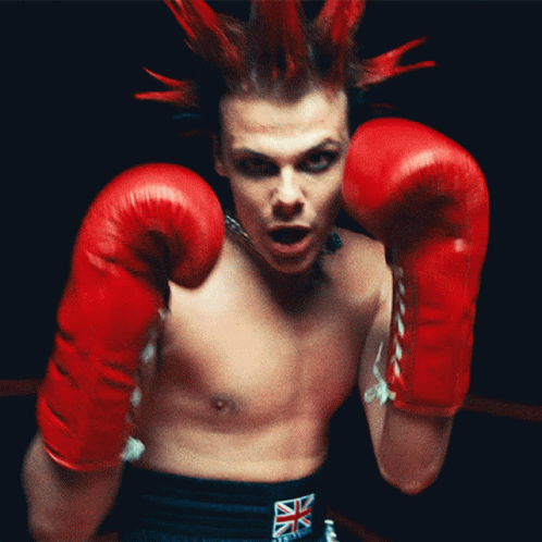 a man with punk hair wearing boxing gloves