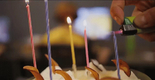 there are candles being cut from a white cake