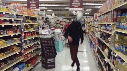 woman walking through store aisle with soda and water