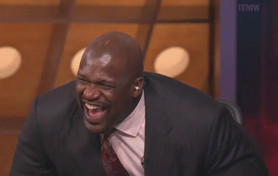 a black man wearing a suit laughing