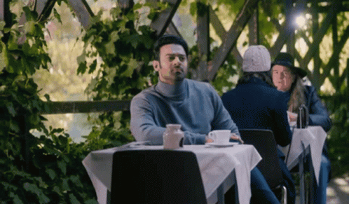 people sitting at tables outside eating and drinking