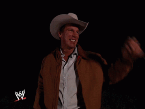 a man wearing a cowboy hat and jacket is smiling