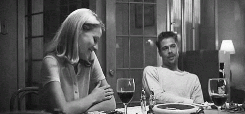man and woman at the dinner table with their wine glasses