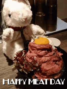 a stuffed bunny next to a plate with blue frosting