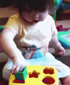a little girl sitting in a high chair with a board in her hands