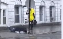 a man walking across the street with his feet propped up on a pole
