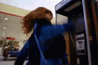 a woman is walking past an atm machine