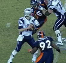 three football players fighting over the ball during a game