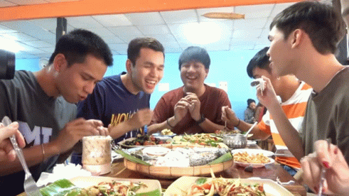 a group of men around a table with food