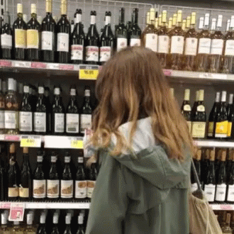a person standing in front of bottles of wine