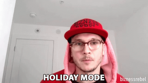 a man with glasses and a hat with the words holiday mode printed on it