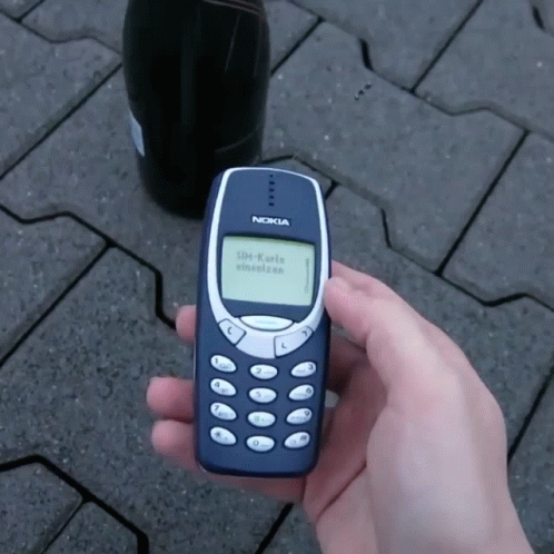 person holding old nokia cell phone in one hand