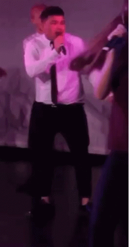 man singing at a purple party in a nightclub