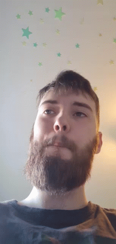 a man has a beard and stares up to the right