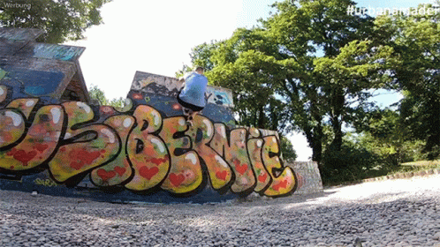 a graffiti painted wall next to a skateboard ramp