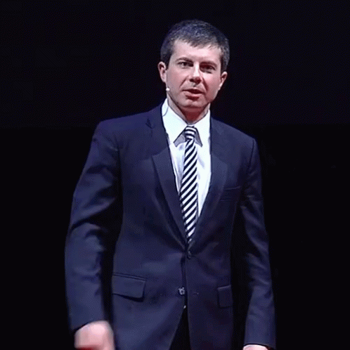 a man wearing a suit and tie standing up
