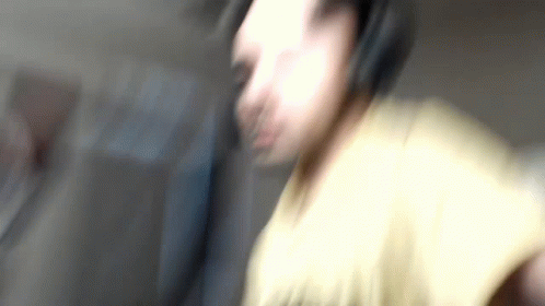 blurry pograph of a man holding a cellular phone