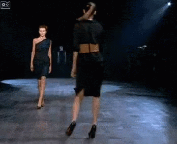 two models walking down a runway on stage