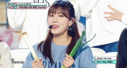 a woman holding a toothbrush while standing in front of another person