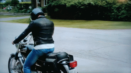 a woman riding on the back of a black motorcycle