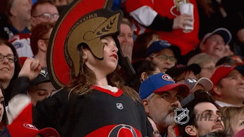 a female hockey fan standing up in front of the oilers