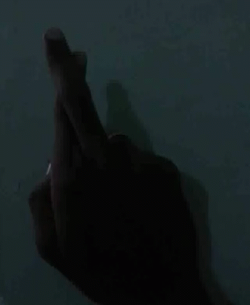 a hand reaching up at soing on a dark surface
