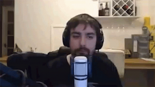 a man with a beard wearing headphones and speaking into a microphone