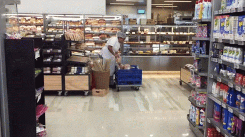 a grocery store aisle with shelves and a man inside