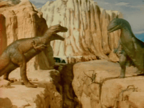 there are several dinosaurs walking on some rocks