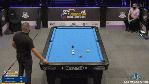 a man standing in front of a pool table with some balls